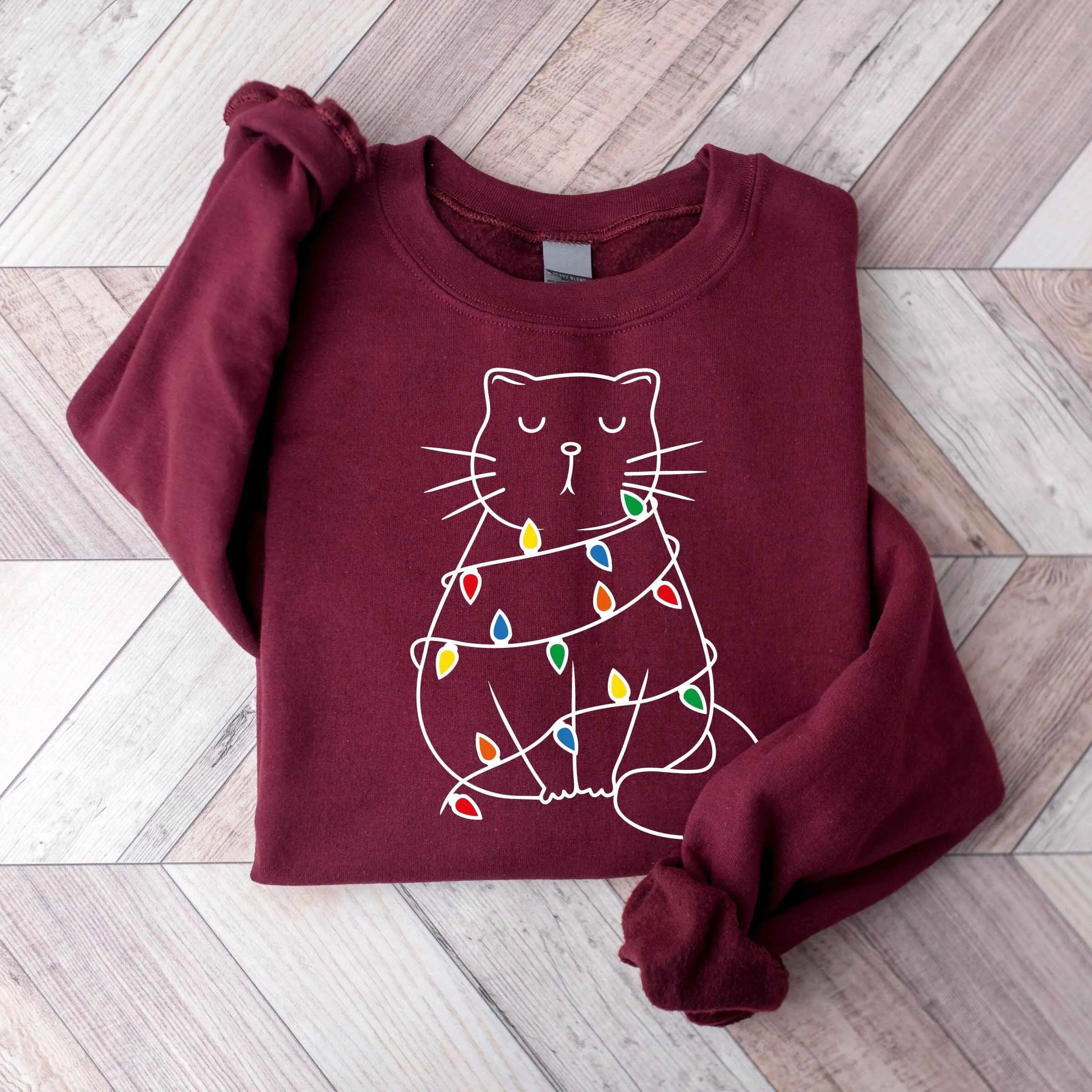 Cozy Cat Wrapped in Christmas Lights Sweatshirt – Pastel Pink Holiday Edition